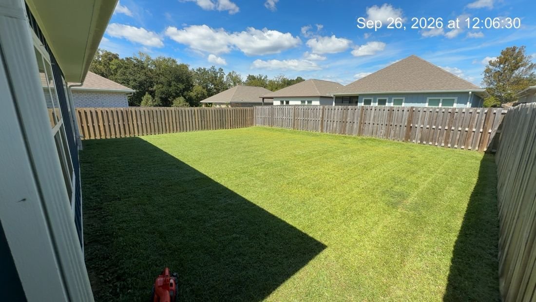 Fenced backyard after mowing